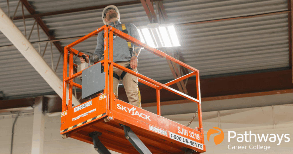 Chris, facilitator at Pathways, demonstrates on a scissor lift what a safe working at heights rigging looks like while operating machiner