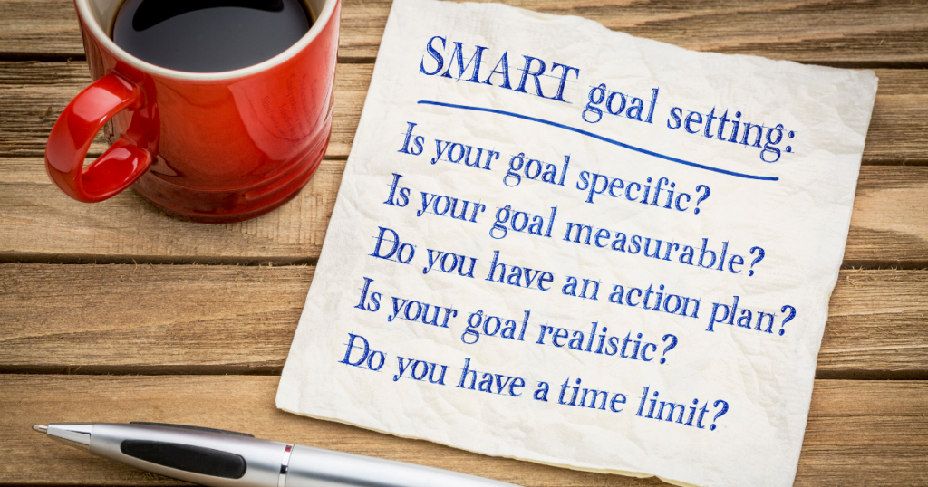 Image of a red coffee cup, a list and pen, showing the SMART goals strategy:
Is your goal specific?
Is your goal measurable?
Do you have an action plan?
Is your goal realistic?
Do you have a time limit?

