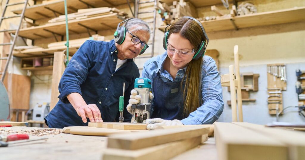 Woodworking learning | Pathways Career College A man teaches a young female student how to use woodworking tools