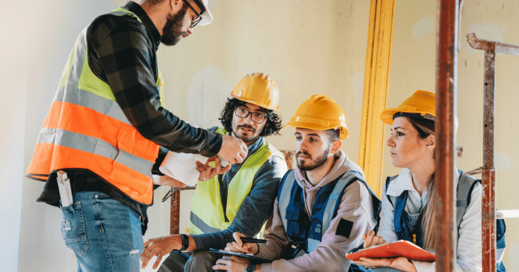 groupconstruction | Pathways Career College three men and a woman in construction hats and vests looking at tools in a micro-credential course