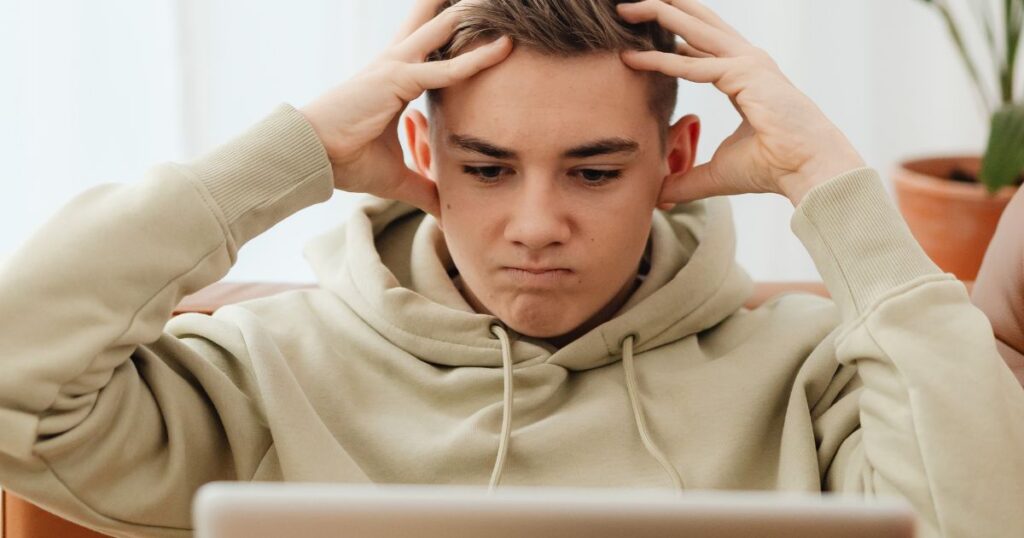 a young frustrated man staring at his laptop