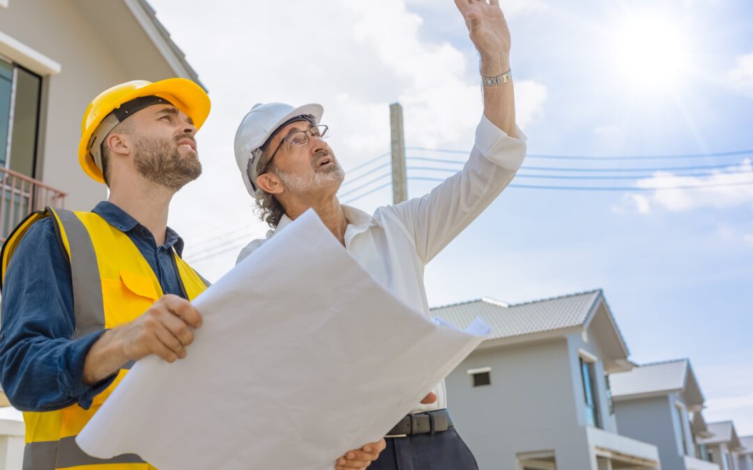 two construction workers reading blueprints and checking buildings