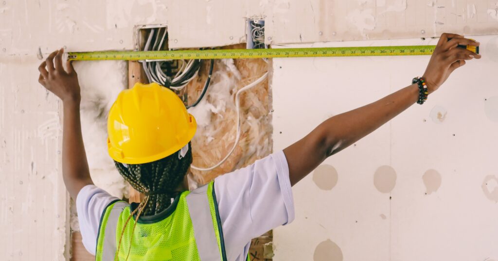 Tape Measure ‣ Pathways Career College Construction Worker measure a wall with a tape measure